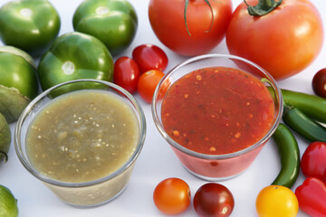 Bowls with delicious salsa sauces and ingredients on white background, closeup