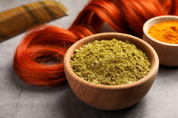 Red strand, henna and turmeric powder on grey table, closeup. Natural hair coloring