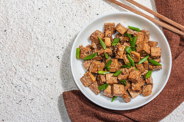 Fried teriyaki Tofu with scallions and sesame seeds. Healthy vegan meatless meal rich in protein