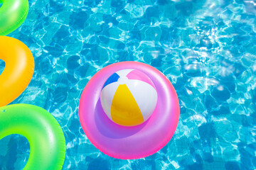 inflatable pool with swimming ring and rings in a water on blue background in the summer day.