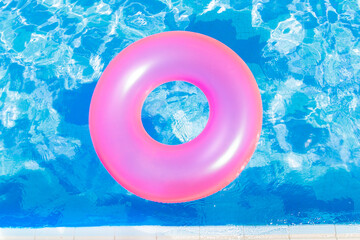 inflatable pool with swimming ring and rings in a water on blue background in the summer day.