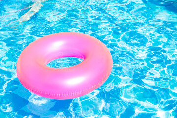 inflatable pool with swimming ring and rings in a water on blue background in the summer day.