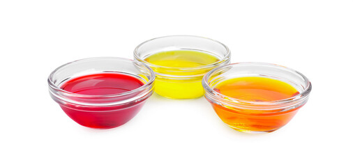 Glass bowls with different food coloring on white background