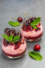Delicious Italian dessert panna cotta with sweet cherry sauce, fresh berries and mint leaves