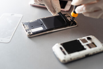 Technician repairing inside of mobile phone by soldering iron. the concept of data, hardware, technology.