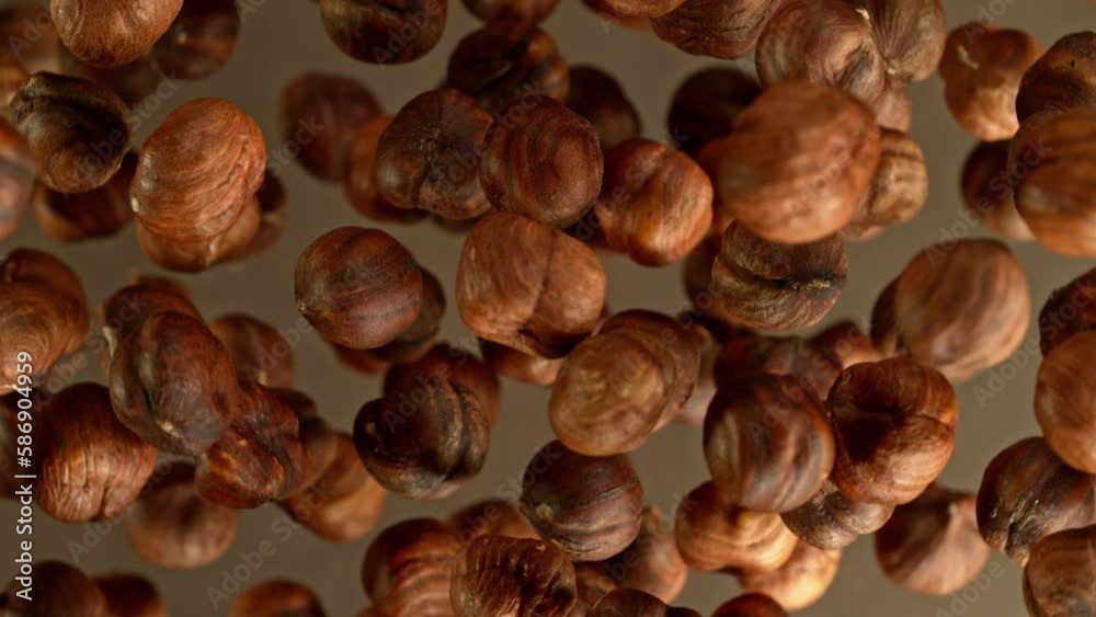 Poster super slow motion of rotating hazelnuts up to the air. filmed on high speed cinema camera, 1000fps, 