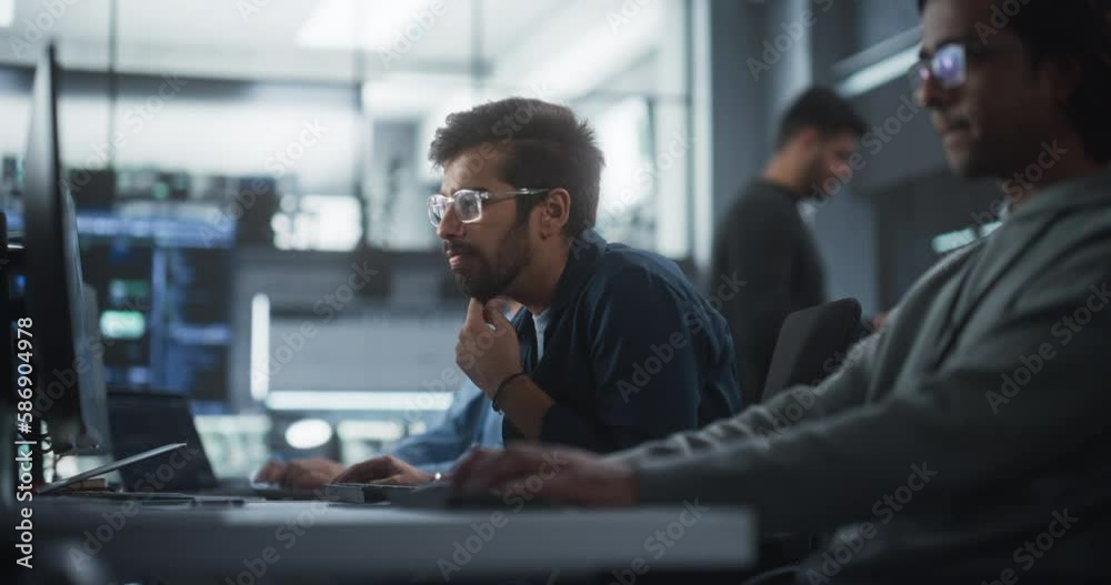 Leinwandbilder focused young indian software developer working on computer together with two creative male colleagu