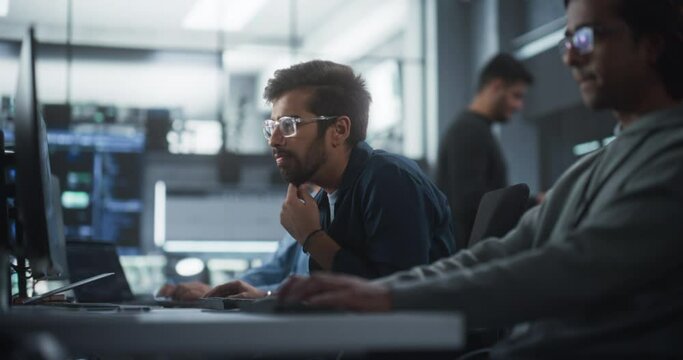 Focused Young Indian Software Developer Working on Computer Together with Two Creative Male Colleagues. Data Protection Center with Servers, Storage Hardware and eBusiness Research and Development
