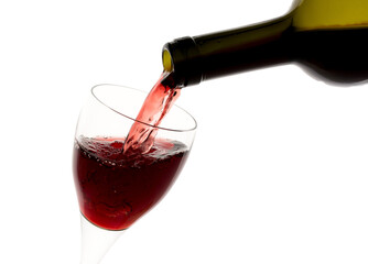 Filling glass with red wine from green bottle