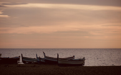 Fishing boat on the shore of the beach.  Sea in the background with space for text. Old fishing boats on the sand.