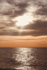 Obraz premium Seascape with beautiful sunlight at sunrise. Sunbeams reflecting blue sea orange sky with space for text.