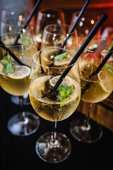 Cocktail with mint lemon. Take a shot. Take your seat. Surprise birthday party. Many glasses with cocktails on the table for guests. Cocktails at the bar scene. Side view.