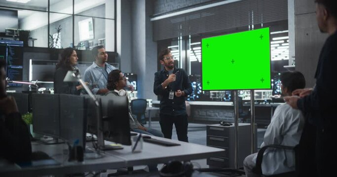 Group of Multiethnic Software Developers Having a Meeting in a Conference Room with Green Screen Mock Up Display. Indian Specialists Brainstorming New Ideas and Solving Problems in the Office