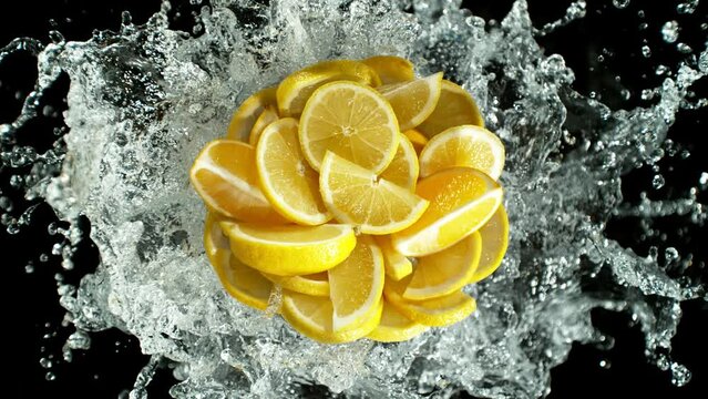 Super slow motion of lemon slices with water splash. Filmed on high speed cinema camera, Isolated on black background.
