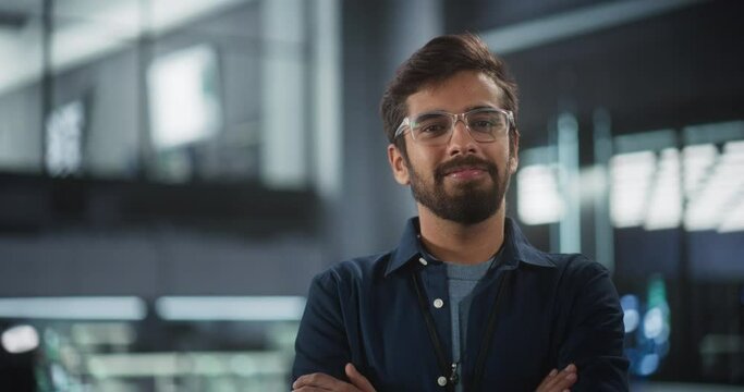 Handsome Indian Wearing Glasses and a Dark Blue Shirt Smiling and Looking at Camera. Young South Asian Man Working as Engineer or Scientist in Technology Research Facility