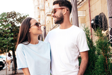 Smiling beautiful woman and her handsome boyfriend. Woman in casual summer jeans clothes. Happy cheerful family. Female having fun. Sexy couple posing in the street at sunny day. In sunglasses