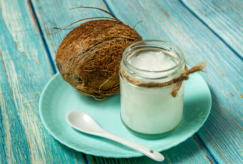 Coconut oil and fresh coconuts on old vlue wooden table