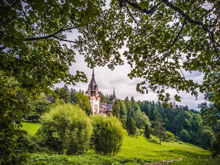 Naklejka premium Park With Trees And Bushes In The Foreground, Peles Castle In The Background