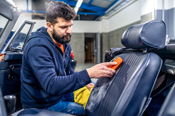 cleaning leather car seats with a brush and chemicals