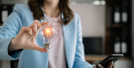 Business women entrepreneurs show creative business strategies with light bulbs as a concept. On the desk in the morning.