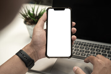 Man holding smartphone with blank screen, close-up of hands. Space for text.