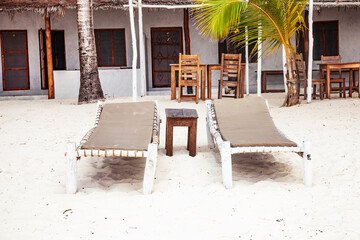 Two sunbeds on tropical sandy beach on Zanzibar, Tanzania.