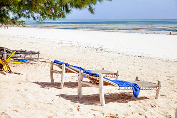 Fototapeta na wymiar Two sunbeds on tropical sandy beach on Zanzibar, Tanzania.