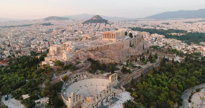 Greece Acropolis city of Athens parthenon symbol of ancient aerial view slide from drone on panorama of residential buildings at sunset summer. Lights sun, lens flare. World Heritage sites. History