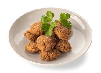 Breaded meatballs fried in white dish with parsley leaves, isolated