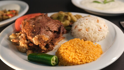 Beef breast ribs served with rice and appetizers on a serving plate