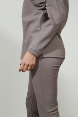 Serie of studio photos of young female model wearing all stone gray comfortable basic outfit, viscose turtleneck and basic flared trousers.