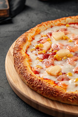 Portion of fresh hawaii pizza with pineapple and ham