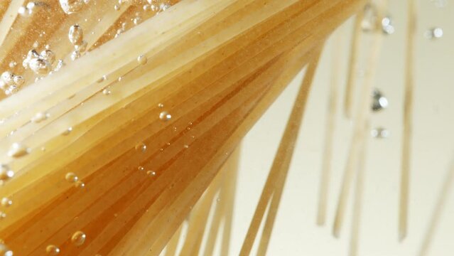 Super slow motion of flying Italian pasta Spaghetti into water. Filmed on high speed cinema camera, 1000 fps.