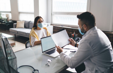 Obraz premium Young woman patient consulting doctor with analysis in clinic
