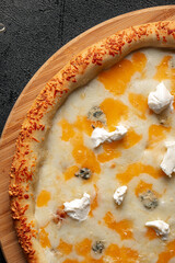 Closeup on four cheese pizza with cheddar and gorgonzola