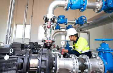 Asia oil and gas production control engineer or supervisor with digital pad monitoring natural gas supply and distribution in refinery Installation view of natural gas refinery pipes
