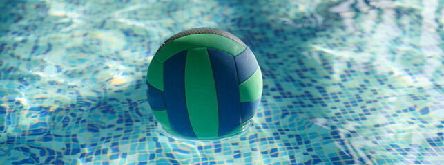 Photography of the swimming pool. Area to play in the water. Water polo ball is lying on the water surface. Sports theme. Healthy lifestyle concept.