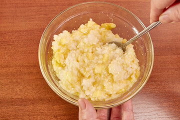 Rice porridge with apples and sugar in a transparent plate.