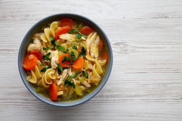 Homemade Chicken Noodle Soup in a Bowl, top view. Flat lay, overhead, from above. Copy space.