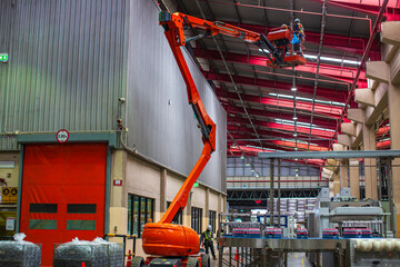 Workers working on the construction site of the new factory industry for boom lift roof © chitsanupong