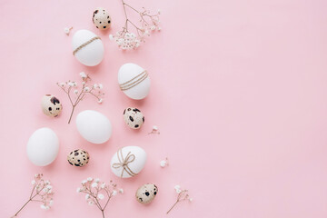 Composition with Easter eggs and spring flowers on pink background. Minimal easter concept.