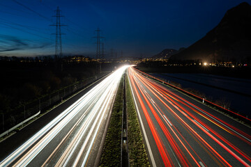 Fototapeta na wymiar Vue des phares en filé sur l'autoroute le soir à 18h30 en direction du Valais en Suisse