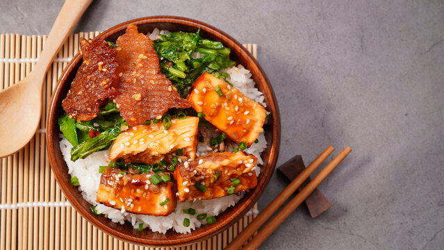 Grilled salmon (toriyaki sauce) and stir-fried vegetables in a brown wooden bowl.