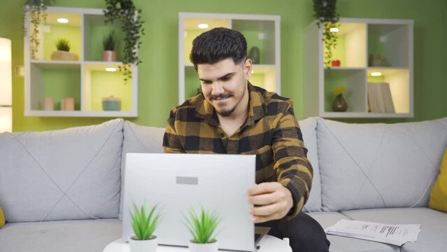 The young man who gets relieved after giving a break continues his work.
Young man working on laptop and documents completed his break. He takes a deep breath and continues his work.
