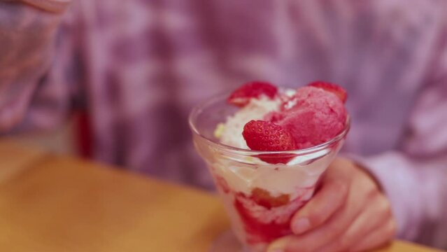 外食先の店で楽しくいちごパフェを食べる小学生の女の子の様子