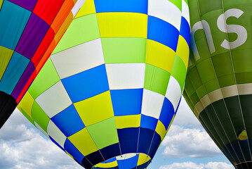 Colorful hot air balloon flying over blue sky with white clouds	