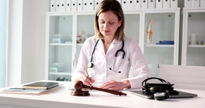 Judge gavel is doctor dealing with paperwork in medical clinic. Litigation and forensic medical examination