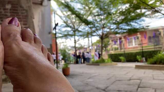 Mature woman's feet obscure the view of Roman Catholic devotees who perform a traditional seven-church visit in observance of the Holy Thursday and Friday as penance. Blurs