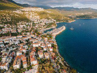 Naklejka premium Aerial drone shot of Kaş center and marina, highlighting the vibrant coastal landscape, turquoise waters, and Mediterranean architecture in Antalya, Turkey.