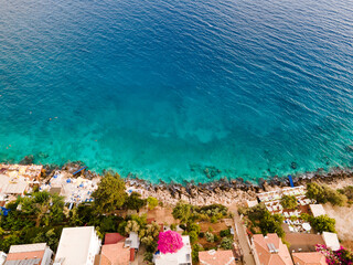 Fototapeta na wymiar Aerial drone photo people swimming in the clear waters of a rocky beach in Kaş, Antalya,